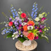 Colorful mixed flower arrangement in a white vase