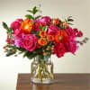 Bright mixed bouquet of pink and orange flowers in a clear glass vase