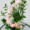 Pink roses with baby's breath in a black vase