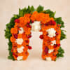 Floral arch covered in orange marigolds, white roses, and red roses
