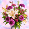 Purple chrysanthemums and white lilies in a striped vase