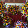 Set of bright mixed funeral sprays and a casket spray with yellow, pink, orange, and purple flowers.