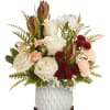 Cream roses and white lilies in a white textured vase with burgundy accents