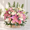 Pink lilies and roses arranged in a wooden box