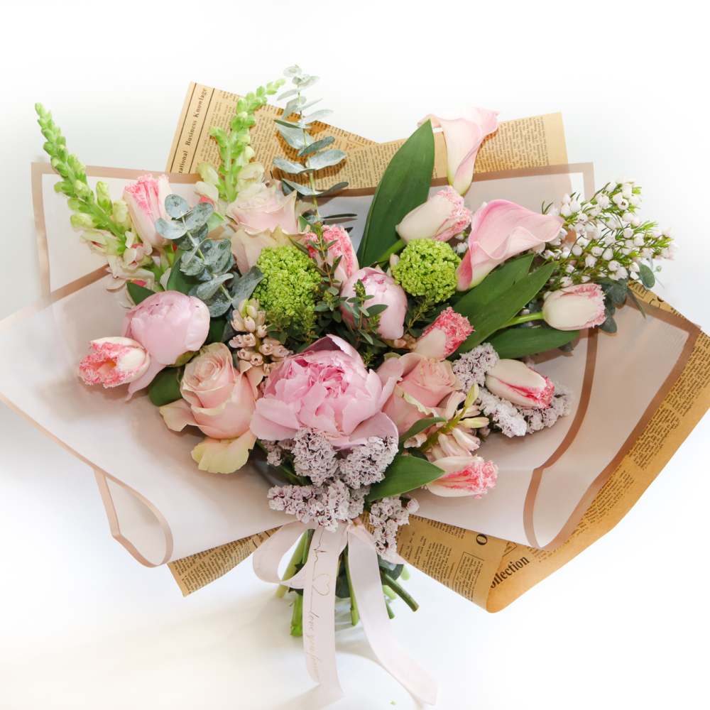 Bouquet of pink flowers wrapped in paper with a ribbon