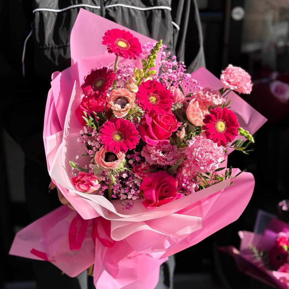 Pink bouquet with roses and gerbera daisies wrapped in pink paper