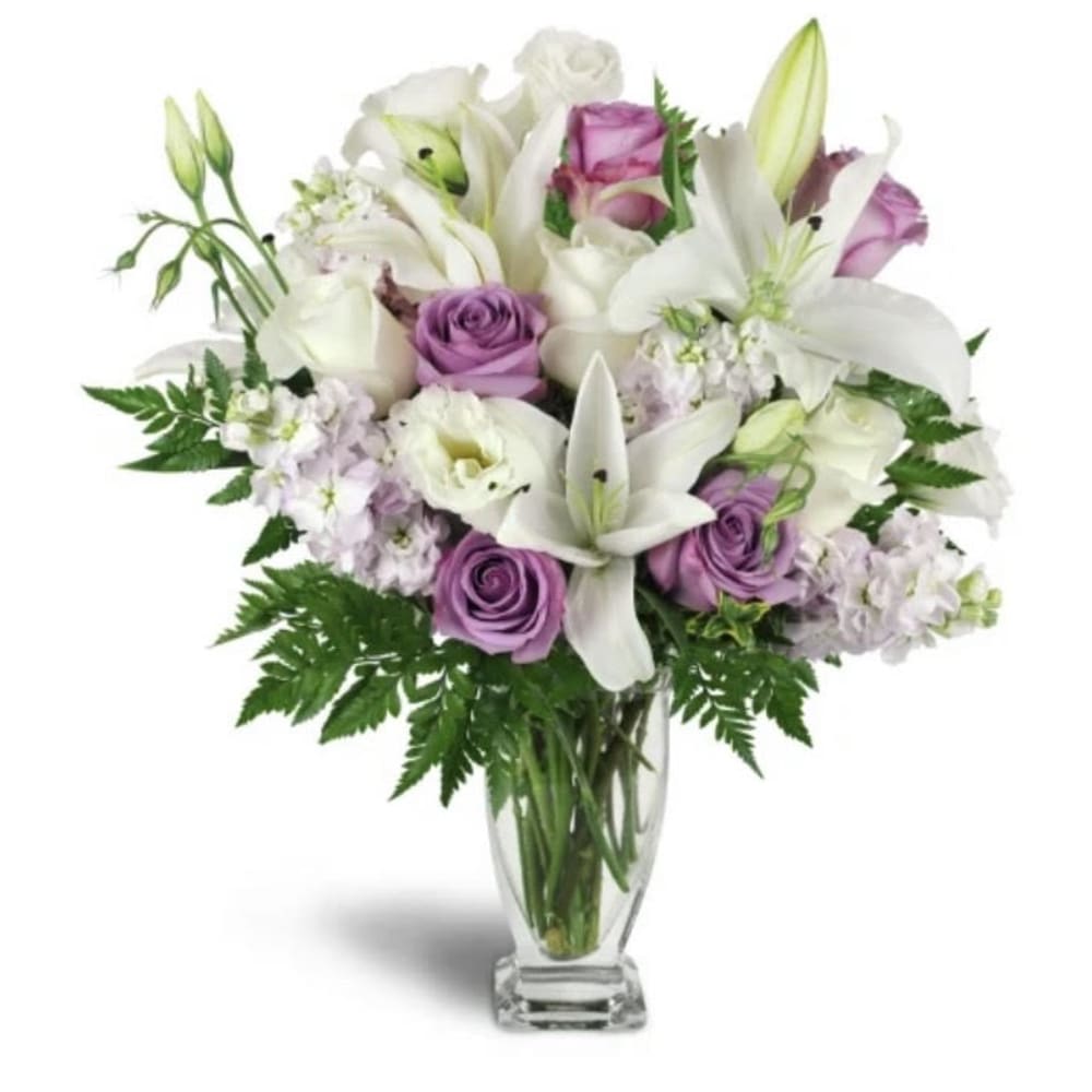 Bouquet of white lilies and lavender roses in a clear glass vase