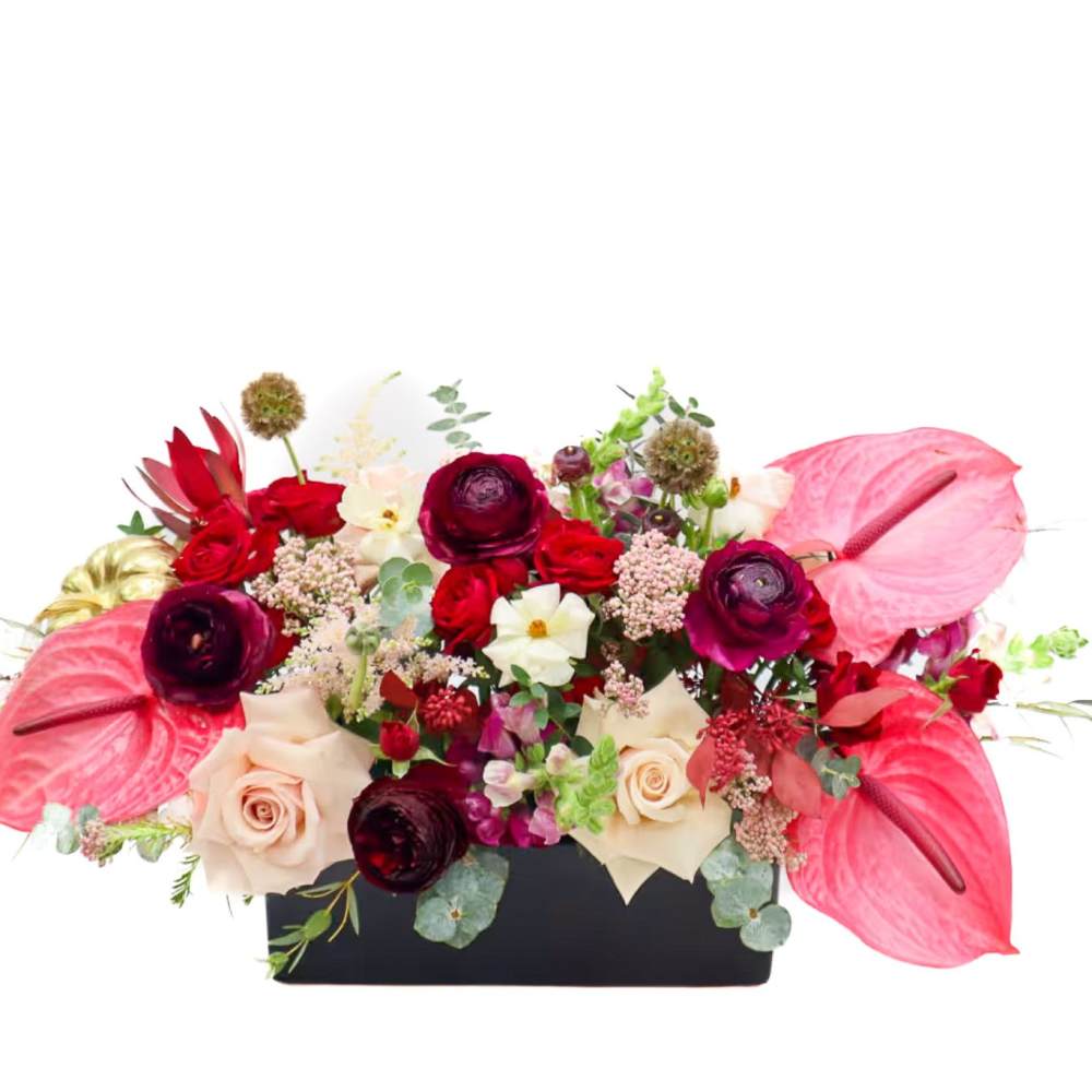 Mixed floral arrangement in a black rectangular container with pink anthuriums and roses