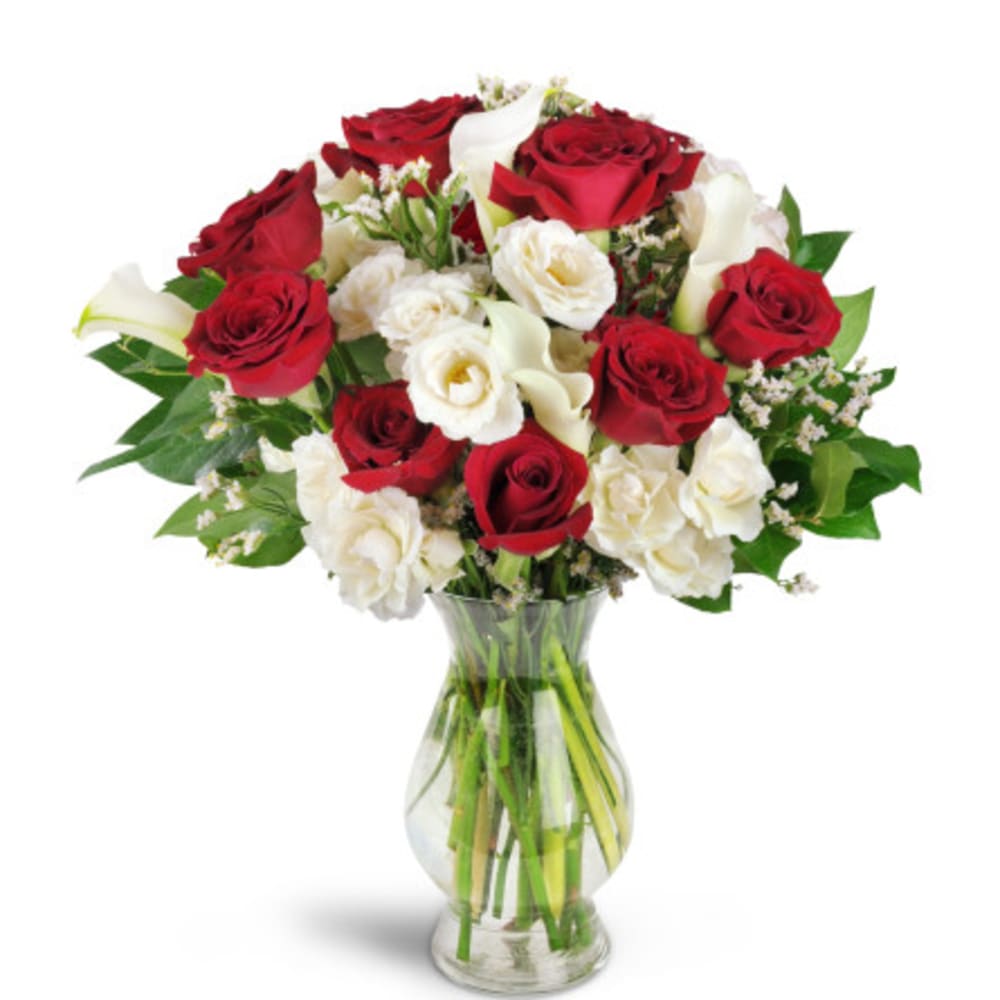 Red and white roses with calla lilies in a glass vase