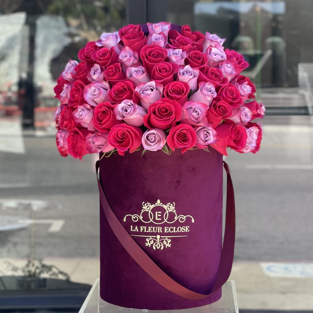 Bouquet of pink and lavender roses in a purple hatbox