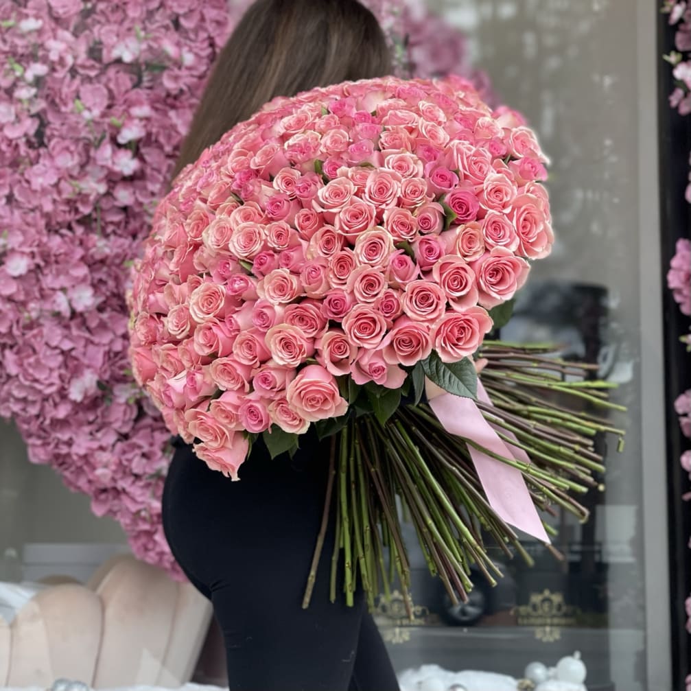 Large bouquet of pink roses tied with a pink ribbon