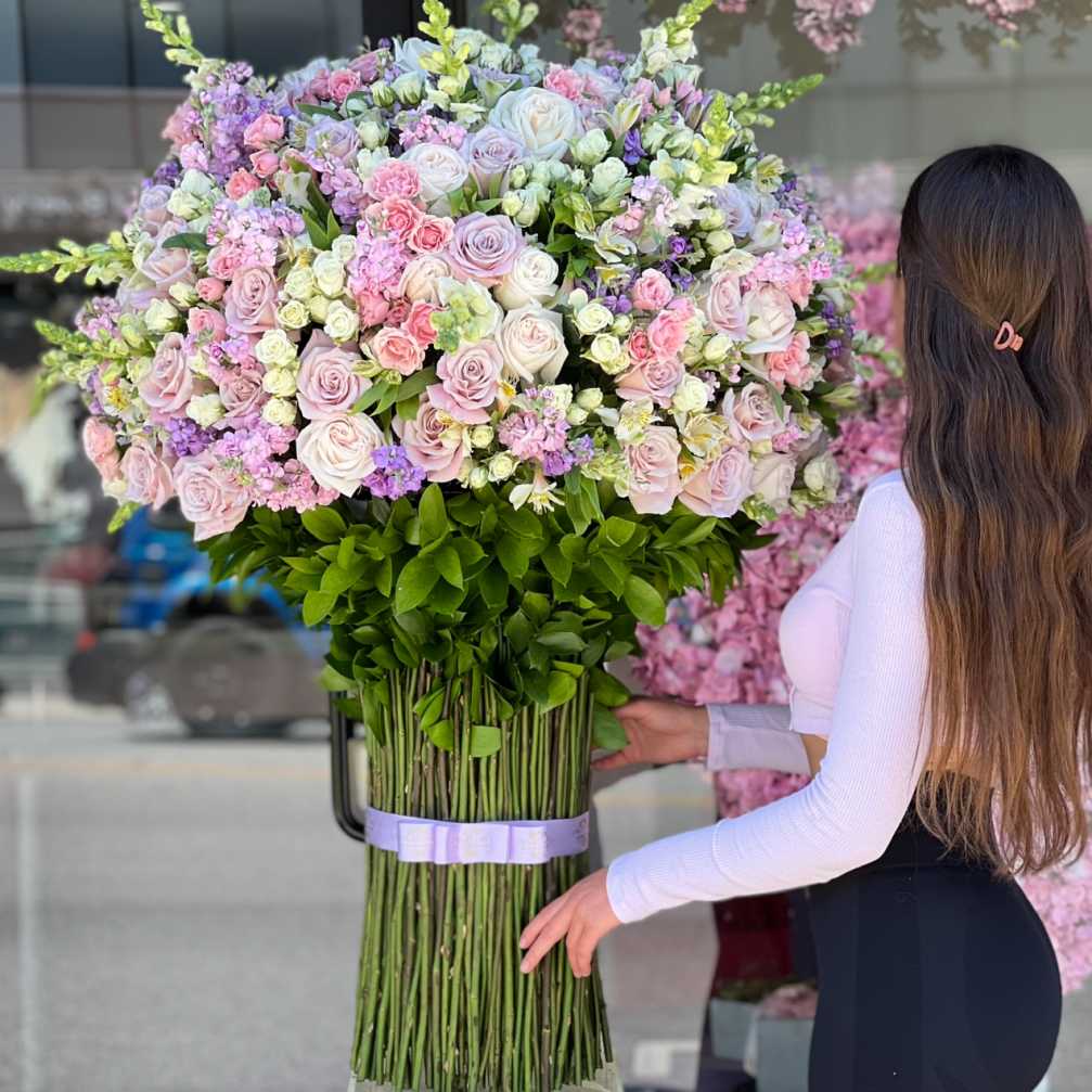 Large bouquet of pink and white roses with purple accents
