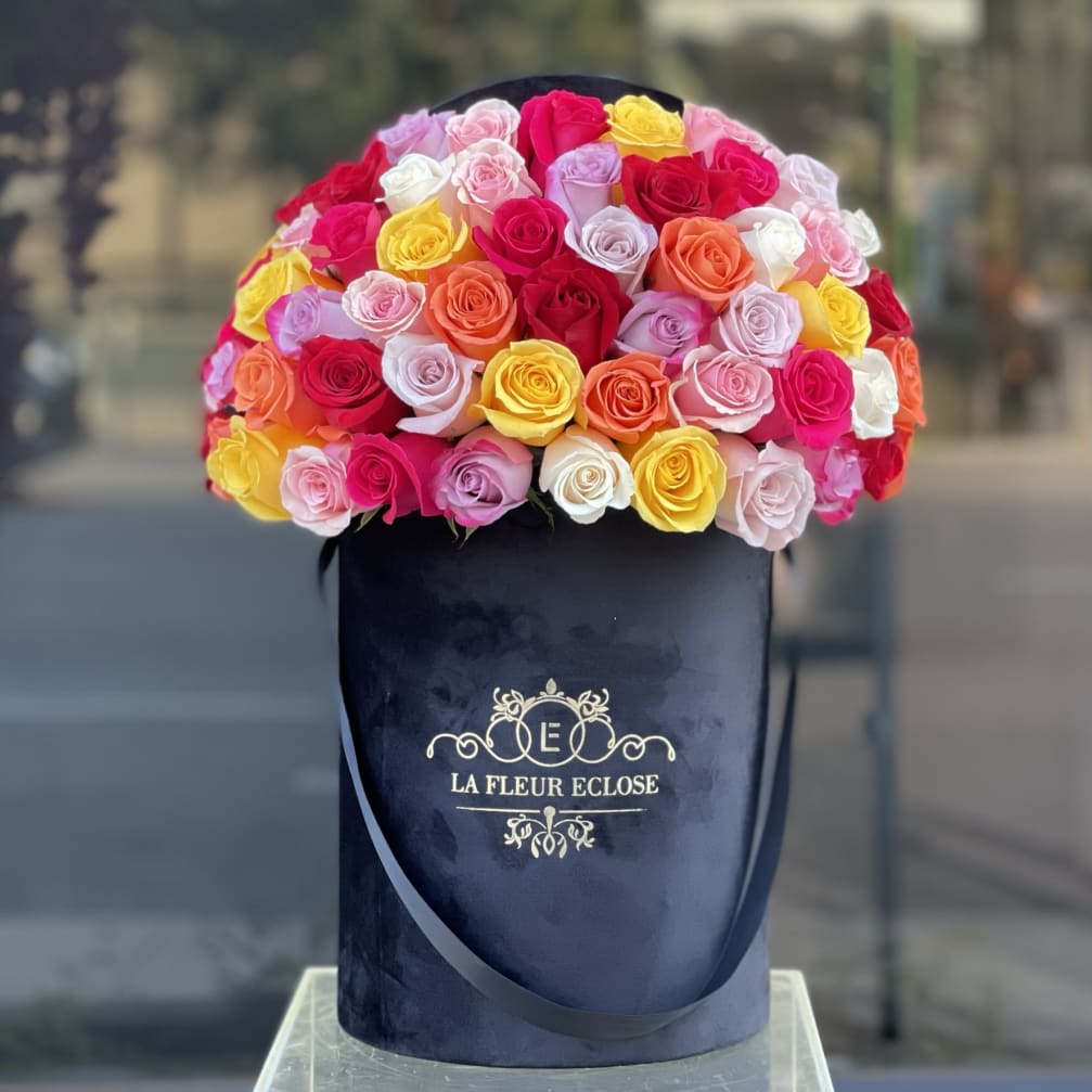 Bouquet of multicolored roses in a navy hatbox