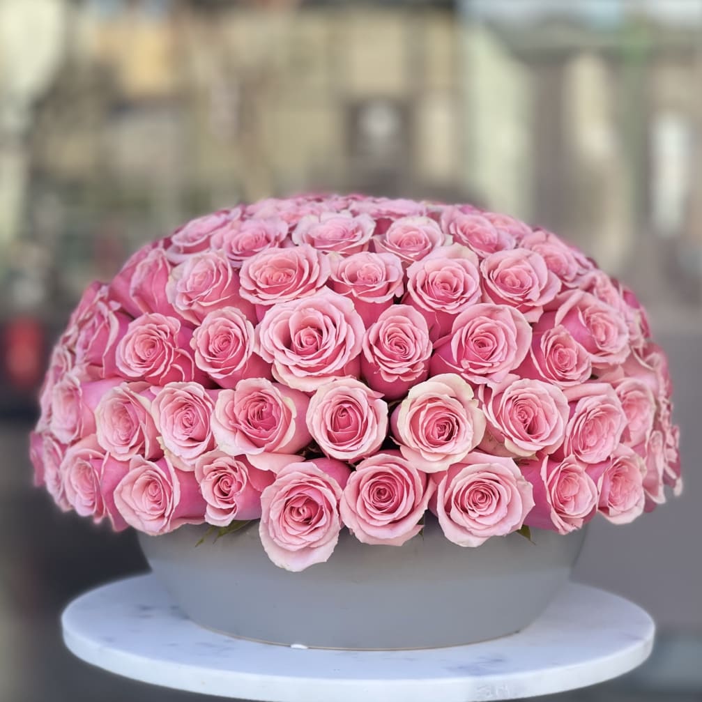 Large dome arrangement of pink roses in a round box