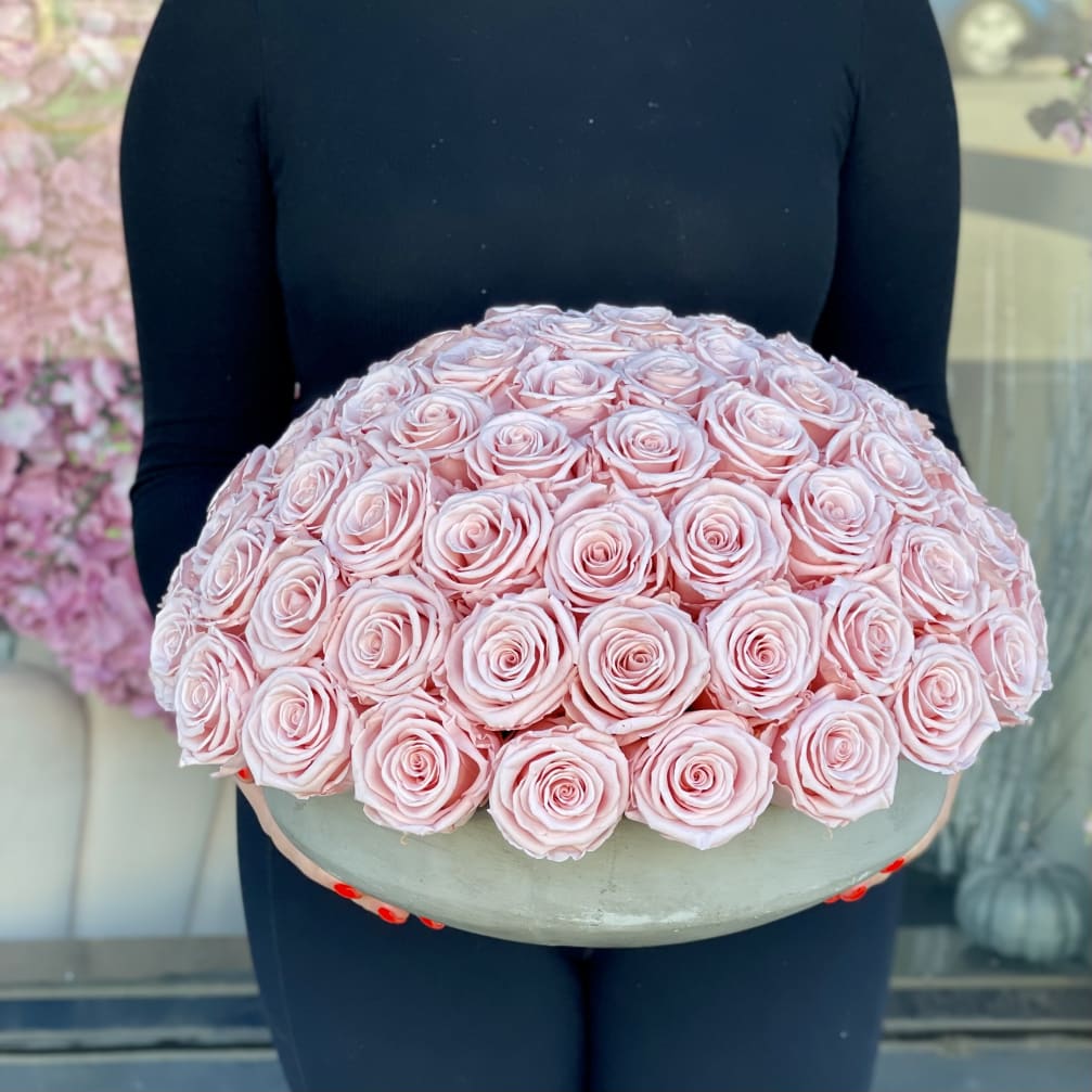 Large dome bouquet of pale pink roses in a round container