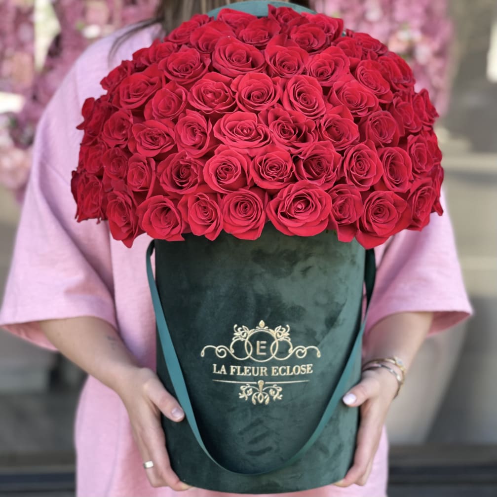 Large bouquet of red roses in a green velvet hatbox
