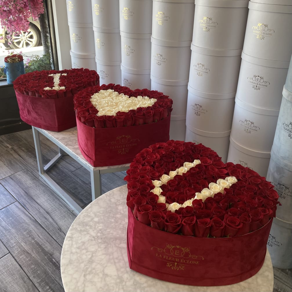 Heart-shaped boxes filled with red and white roses
