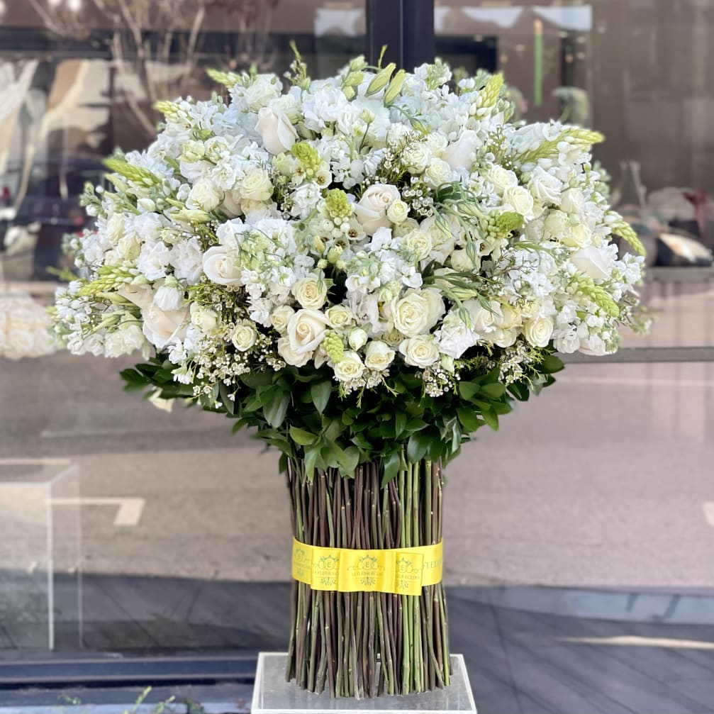 Large white floral arrangement with roses and other blooms