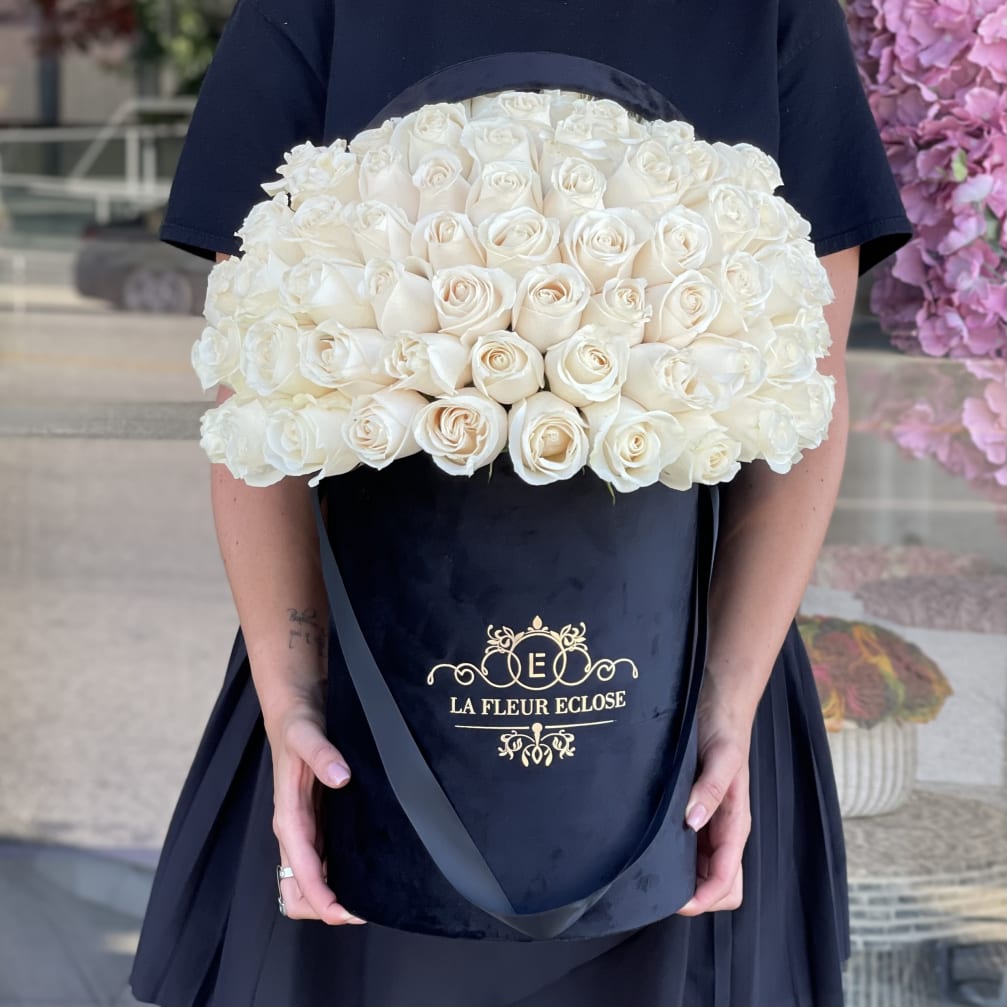 Large bouquet of white roses in a black hatbox