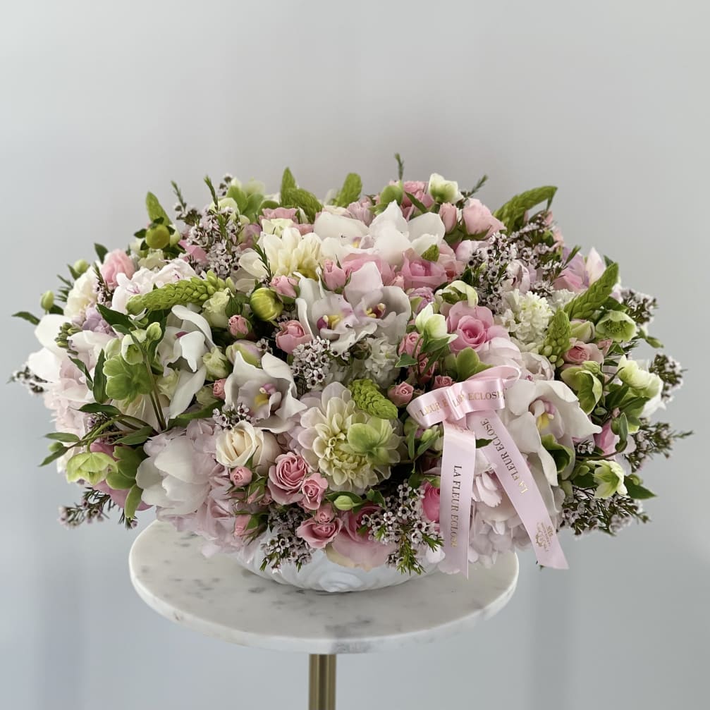 Large pastel bouquet of pink and white flowers in a low vase