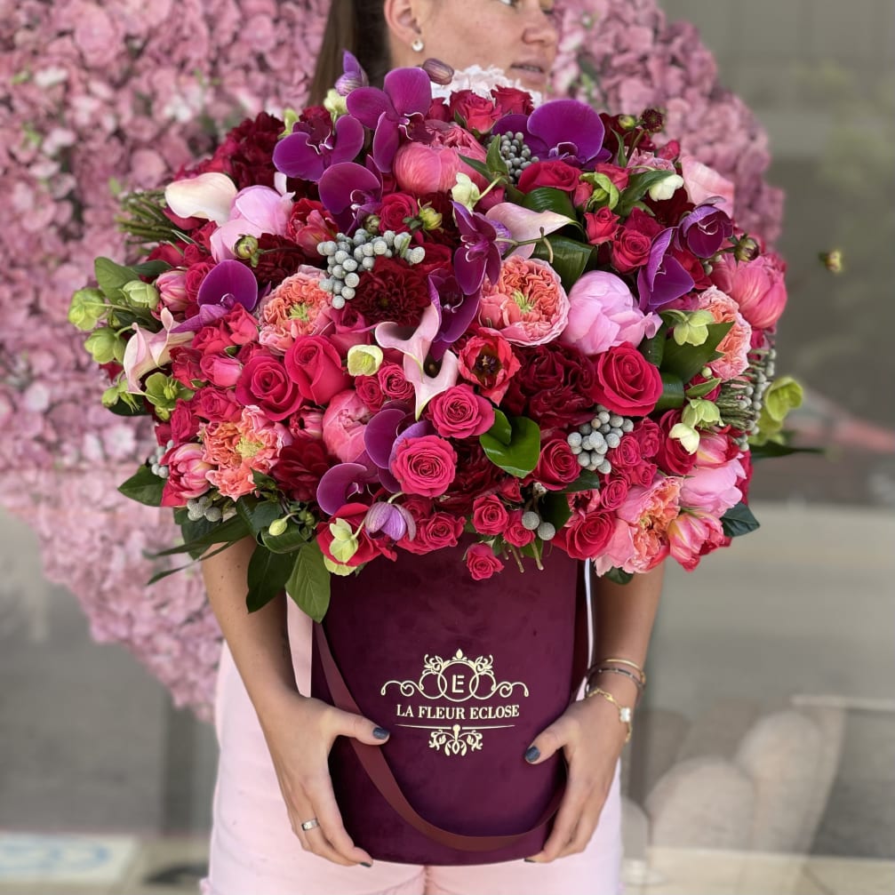 Large bouquet of pink and purple flowers in a burgundy box