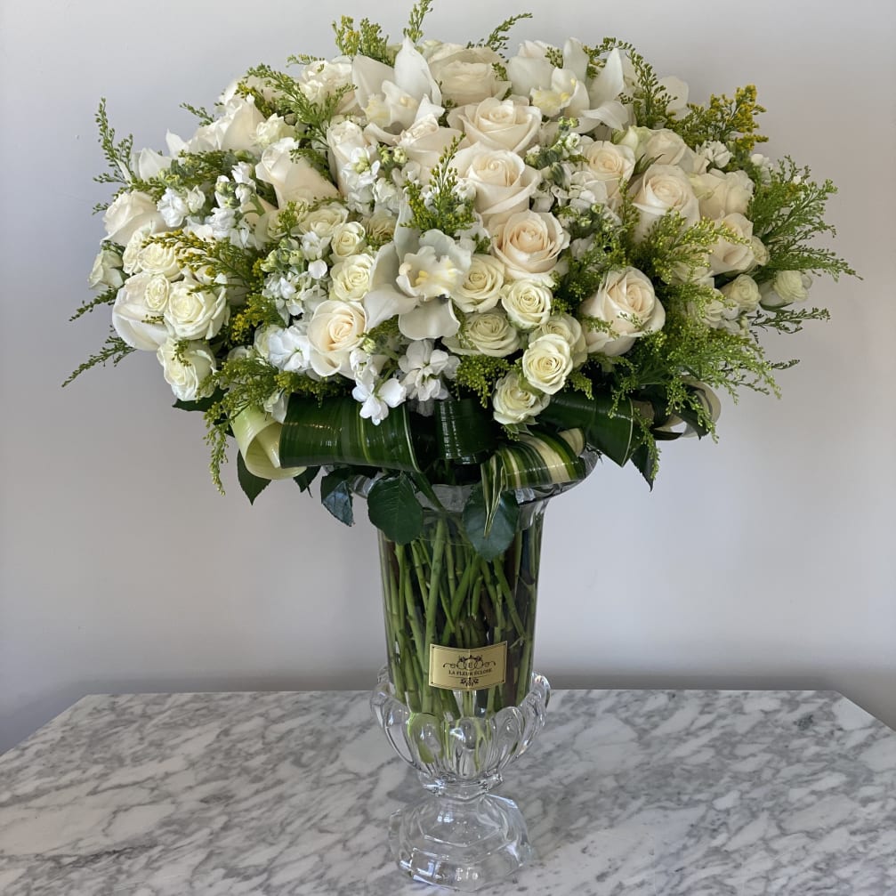 Large white rose arrangement in a clear glass vase
