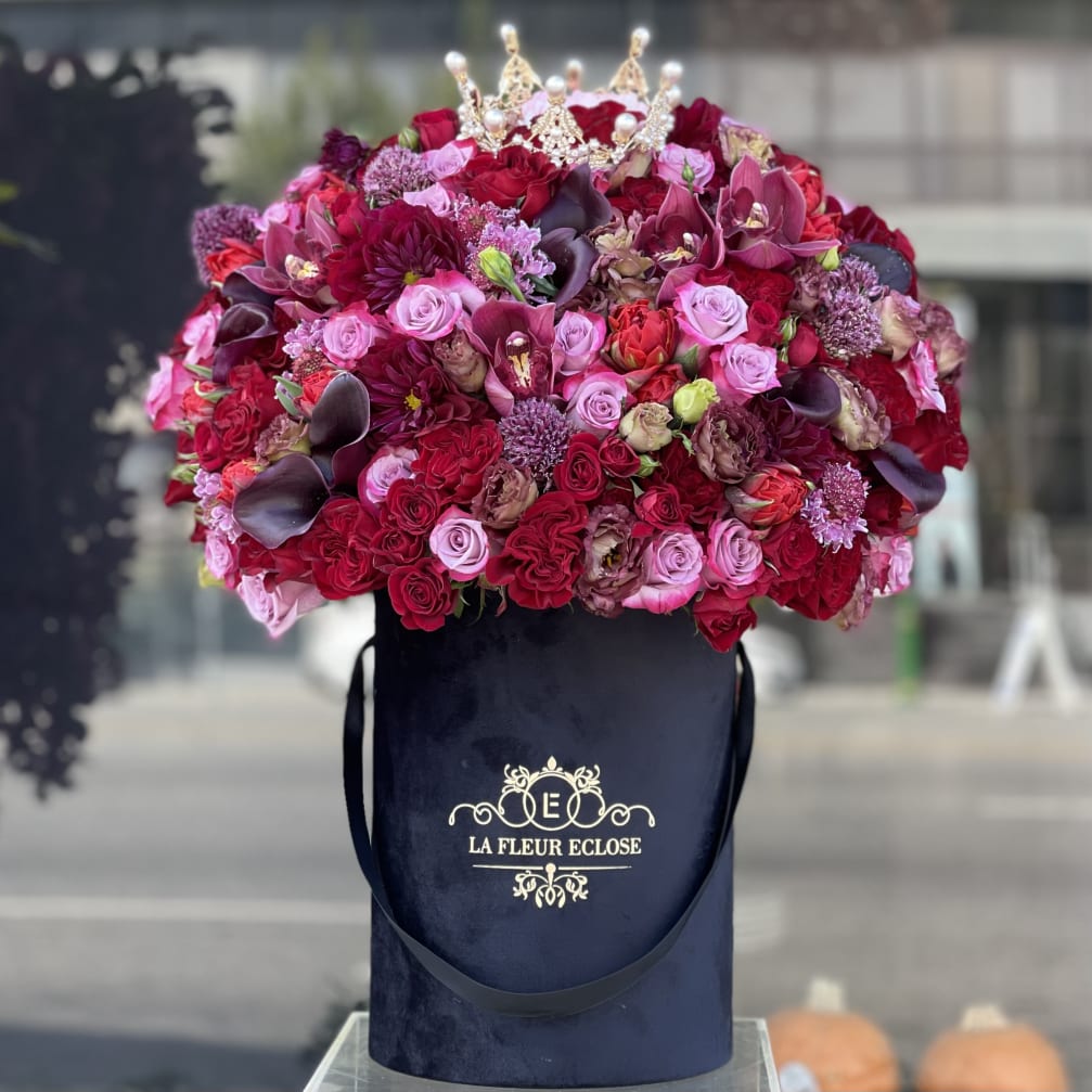 Large pink and red rose arrangement in a navy hat box