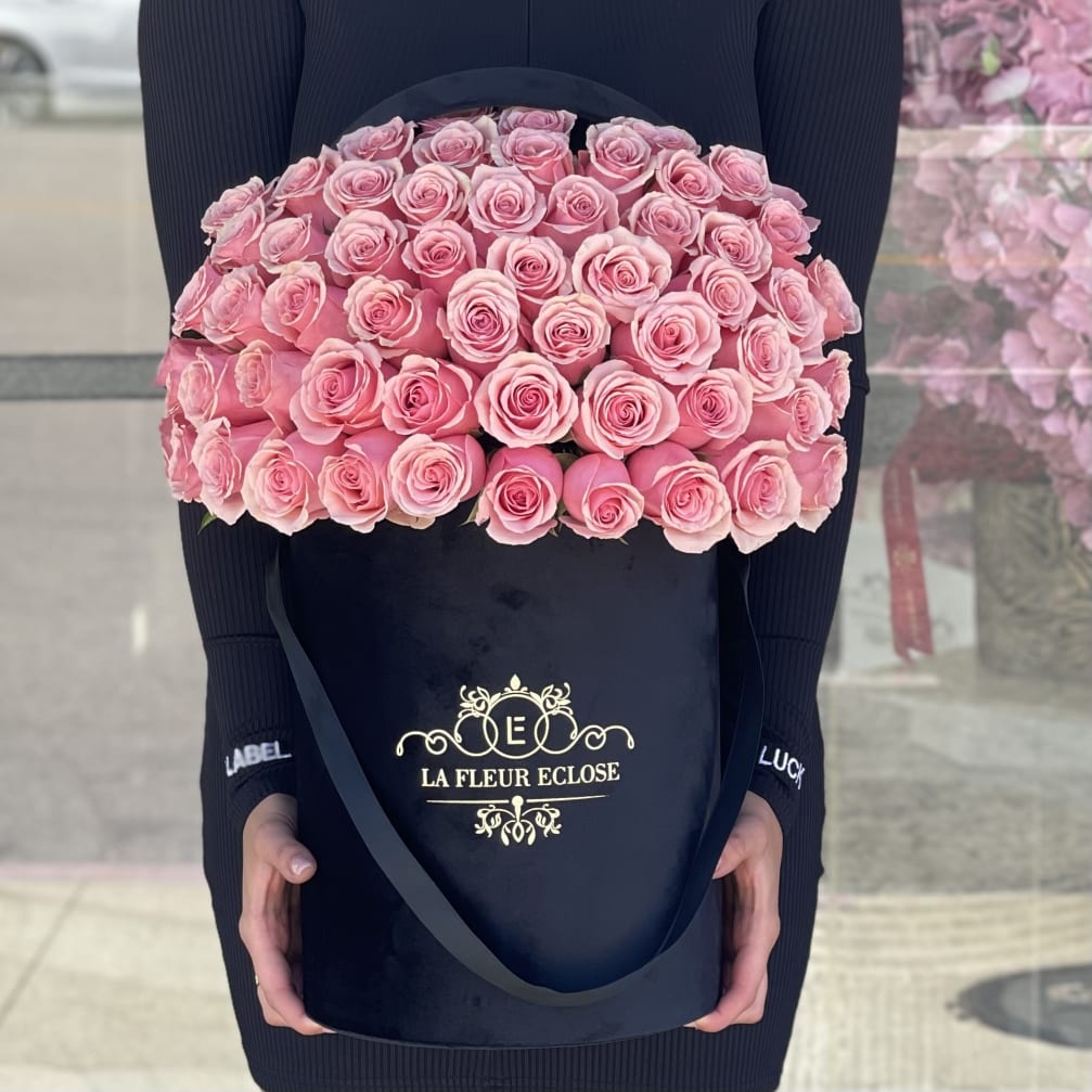 Large box of pink roses held by a person