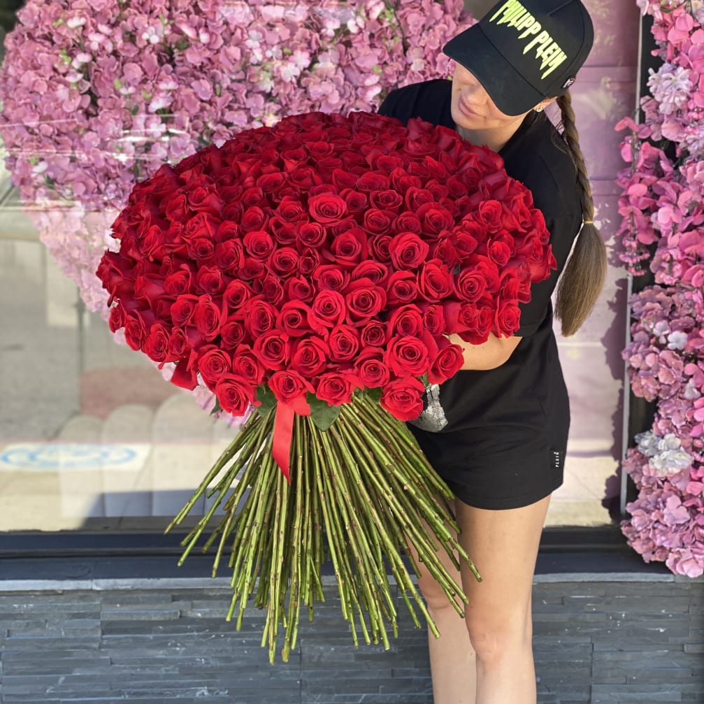 Woman holding a large bouquet of red roses