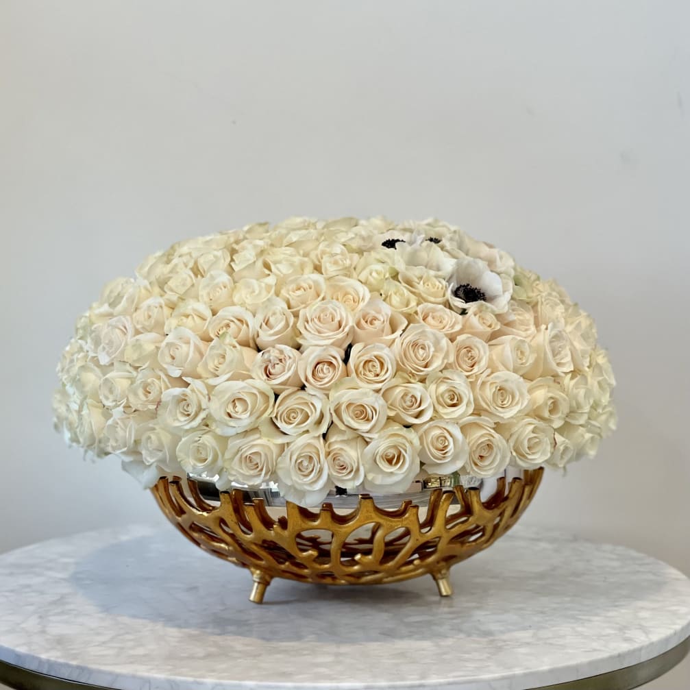 Cream rose arrangement in a gold decorative bowl