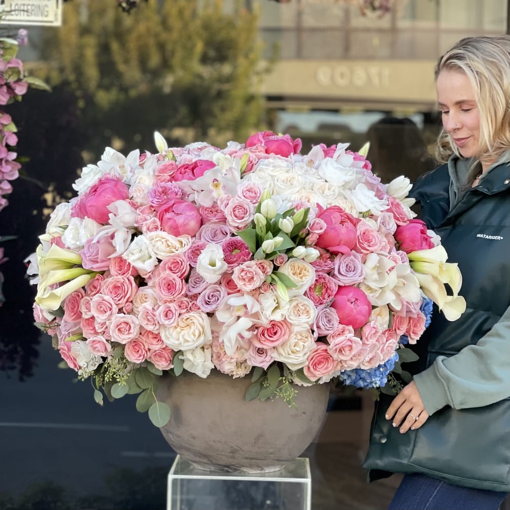 Large pink and white floral arrangement in a round vase