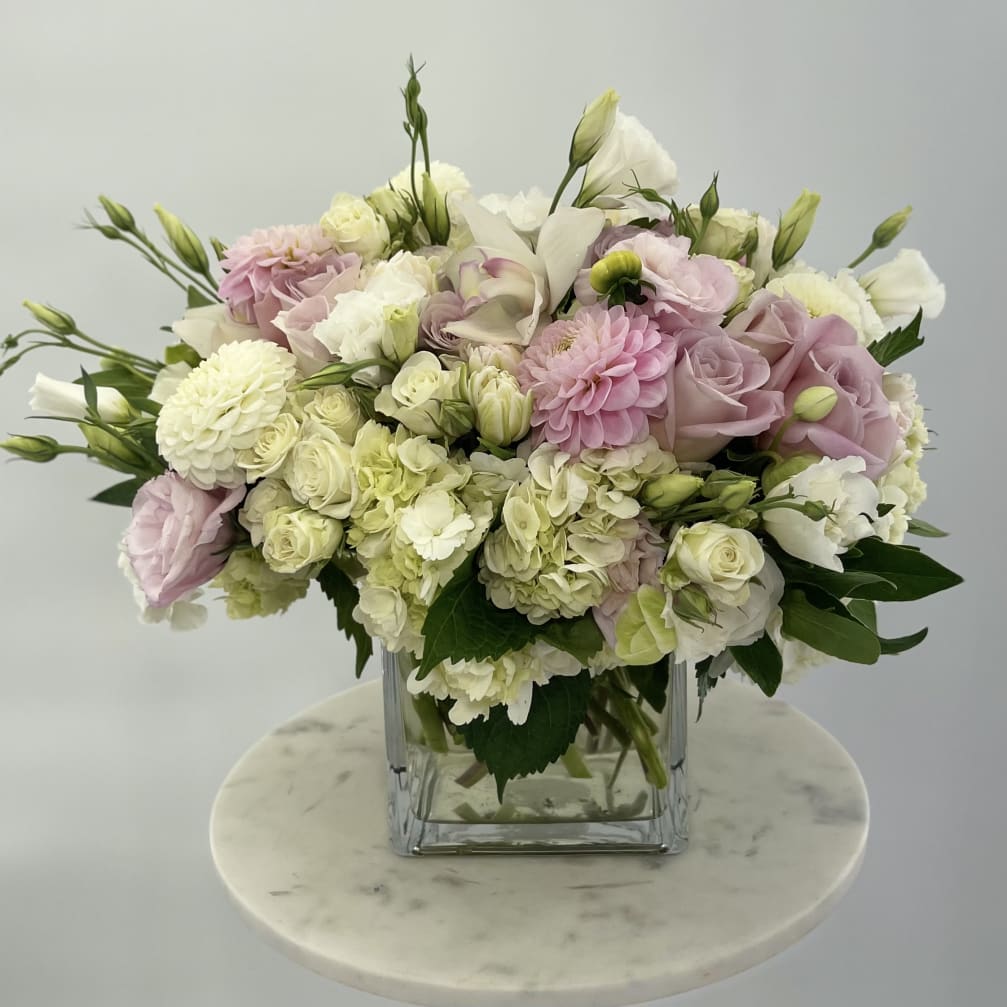 Pink and white mixed bouquet in a clear square vase