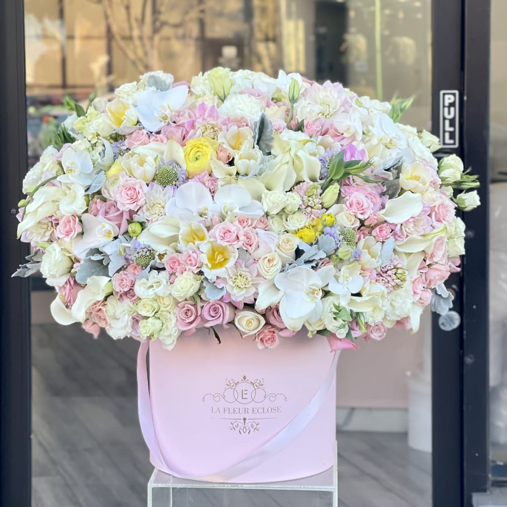 Large pastel flower arrangement in a pink hat box