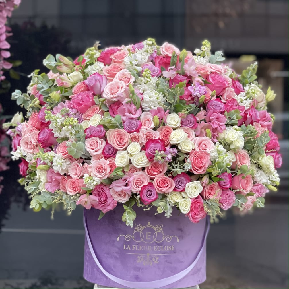 Large pink and white rose arrangement in a purple hat box