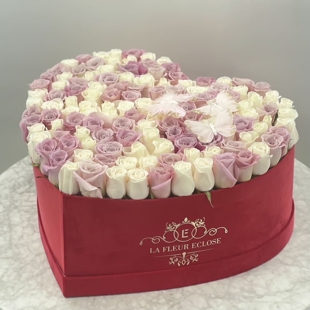 Heart-shaped box of pink and white roses with butterfly accents