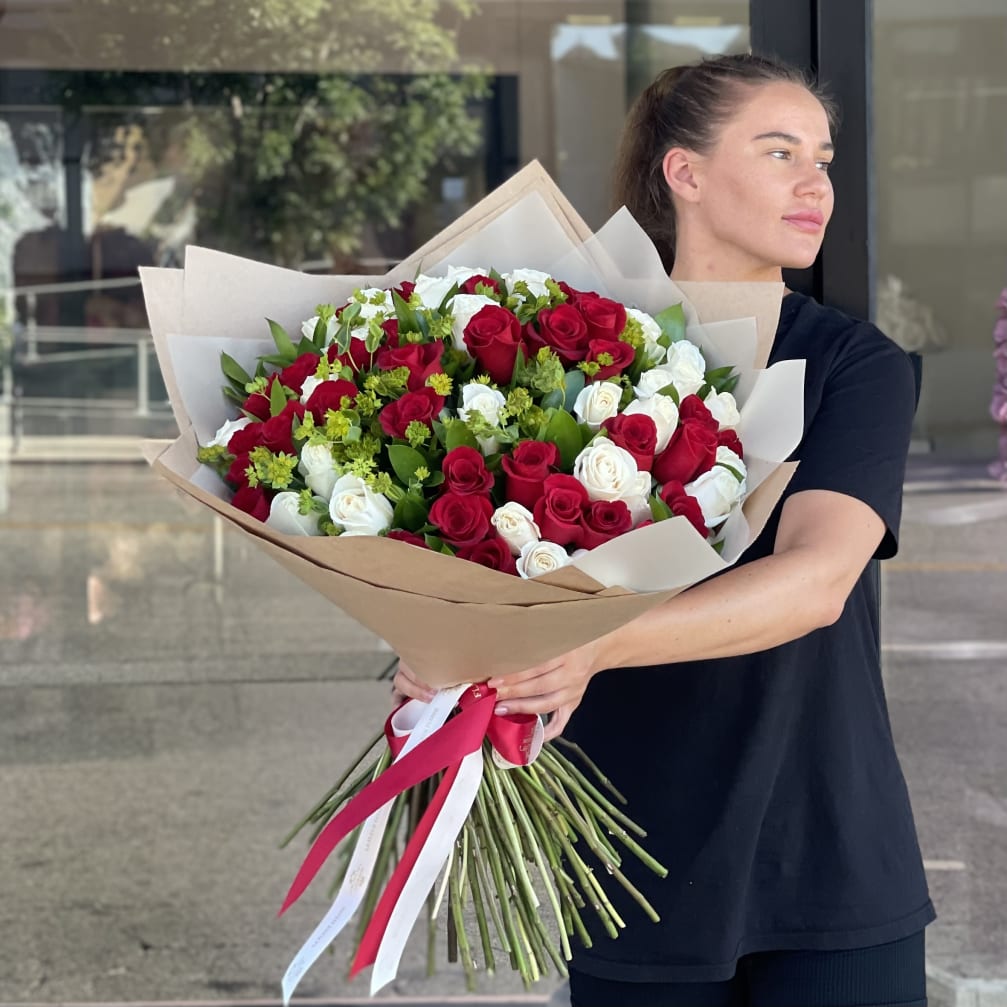 Large bouquet of red and white roses wrapped in brown paper