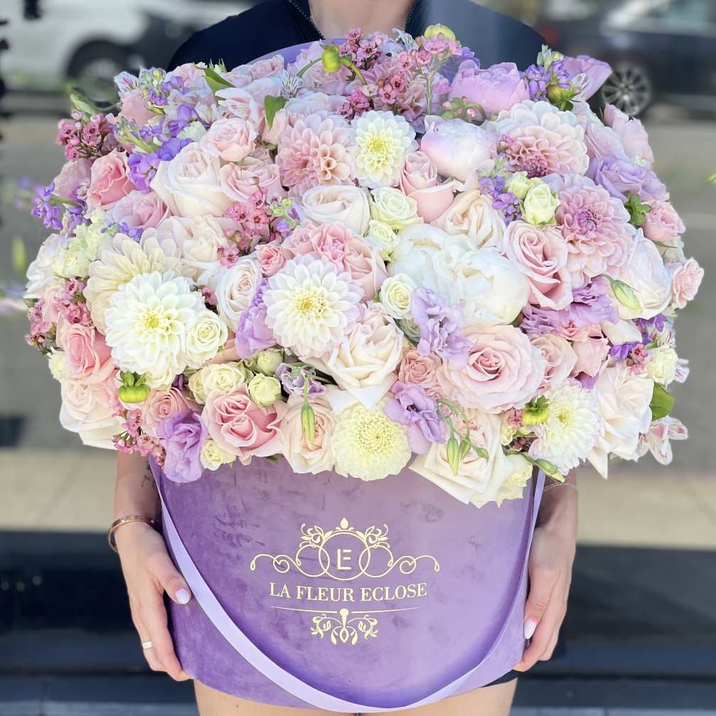Large pastel bouquet of roses, dahlias, and lisianthus in a purple box