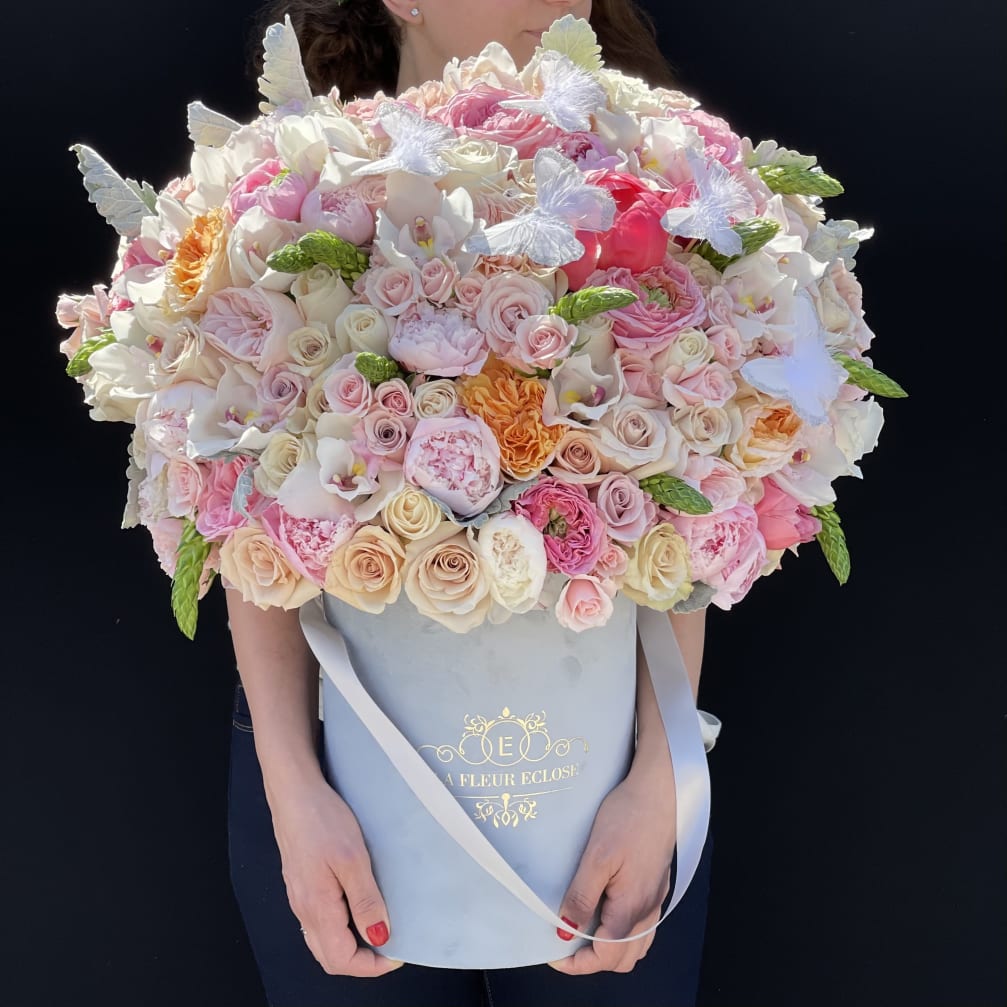 Large pastel bouquet of roses and orchids in a blue hat box