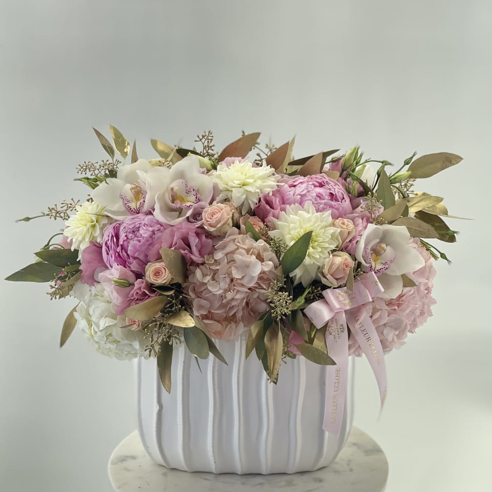 Pink and white floral arrangement in a white ribbed vase