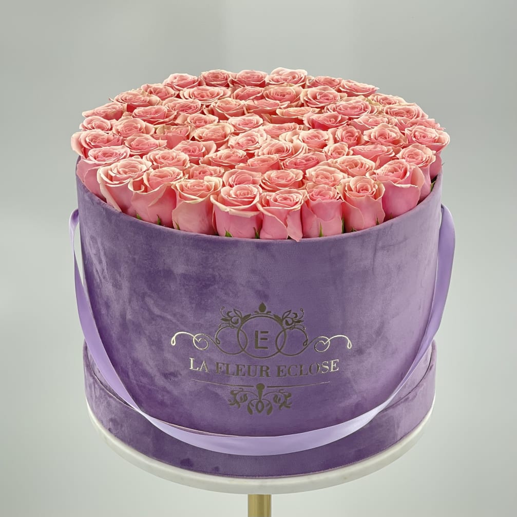Round box of pink roses with a lavender ribbon