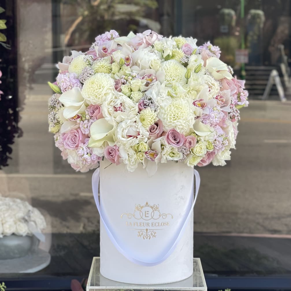 Large pastel bouquet in a white hatbox with a ribbon handle