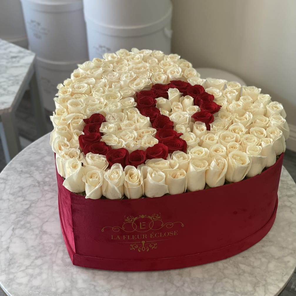 Heart-shaped box filled with white and red roses