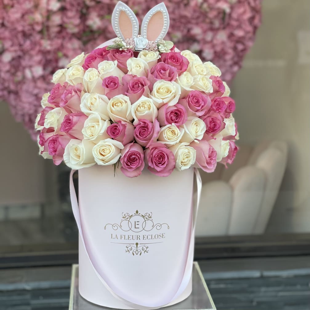 Pink and white roses in a white hatbox with bunny ears