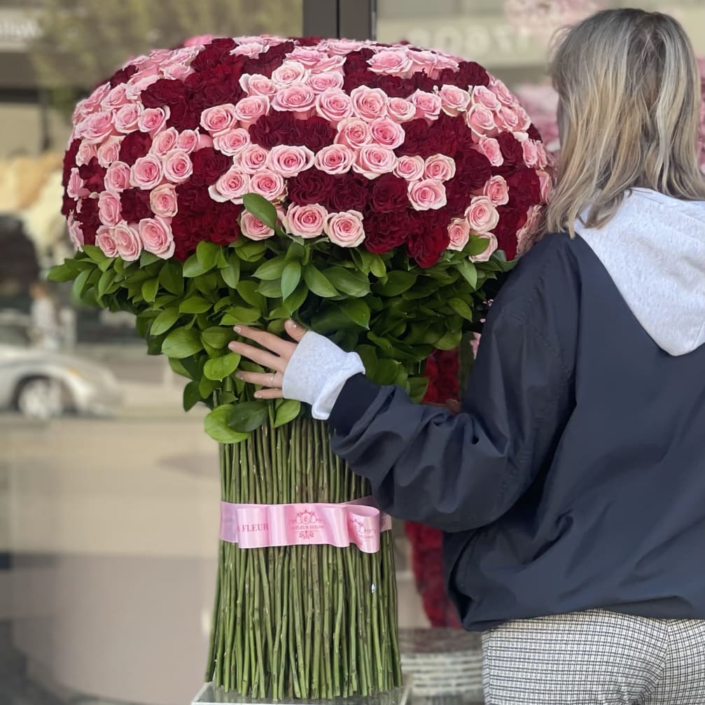 Large bouquet of pink and burgundy roses with a pink ribbon wrap