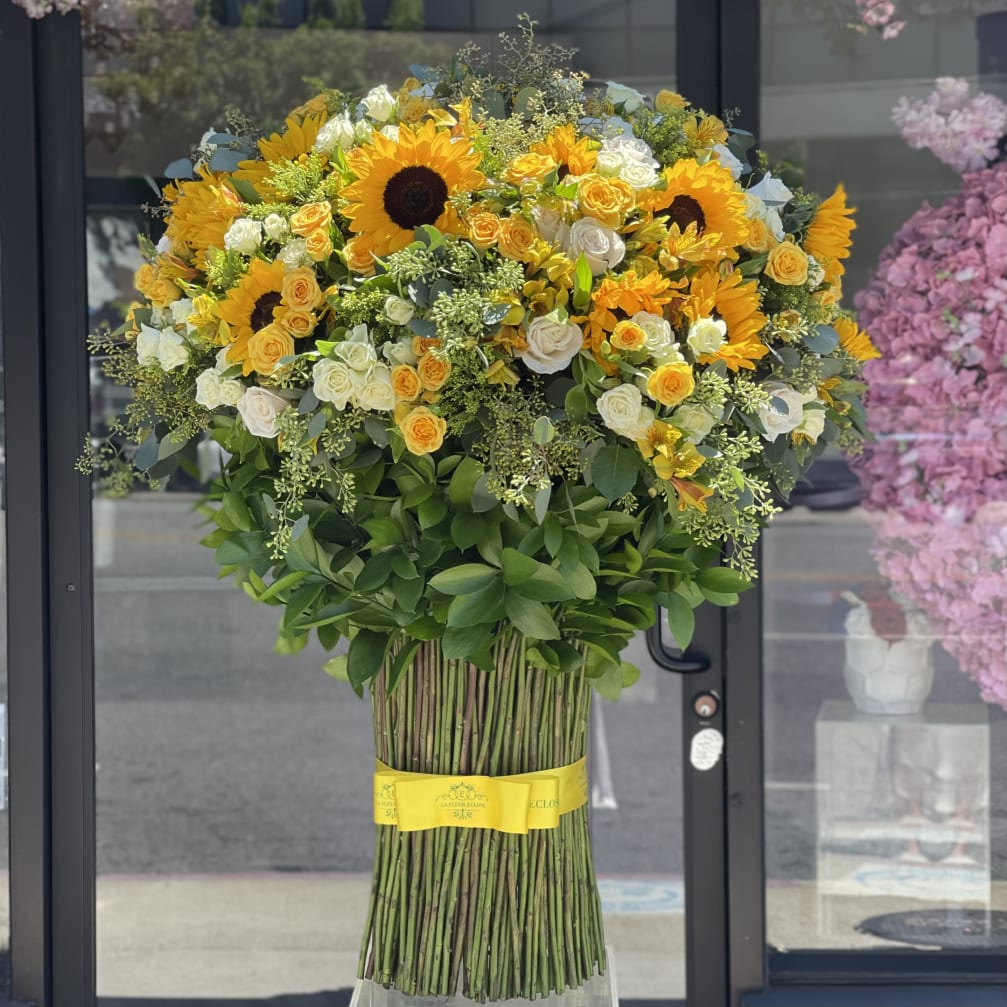 Large bouquet of sunflowers and white roses with a yellow ribbon
