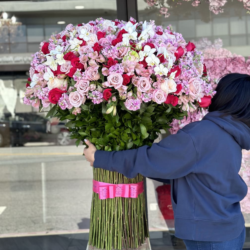 Large bouquet of pink and red roses with white orchids
