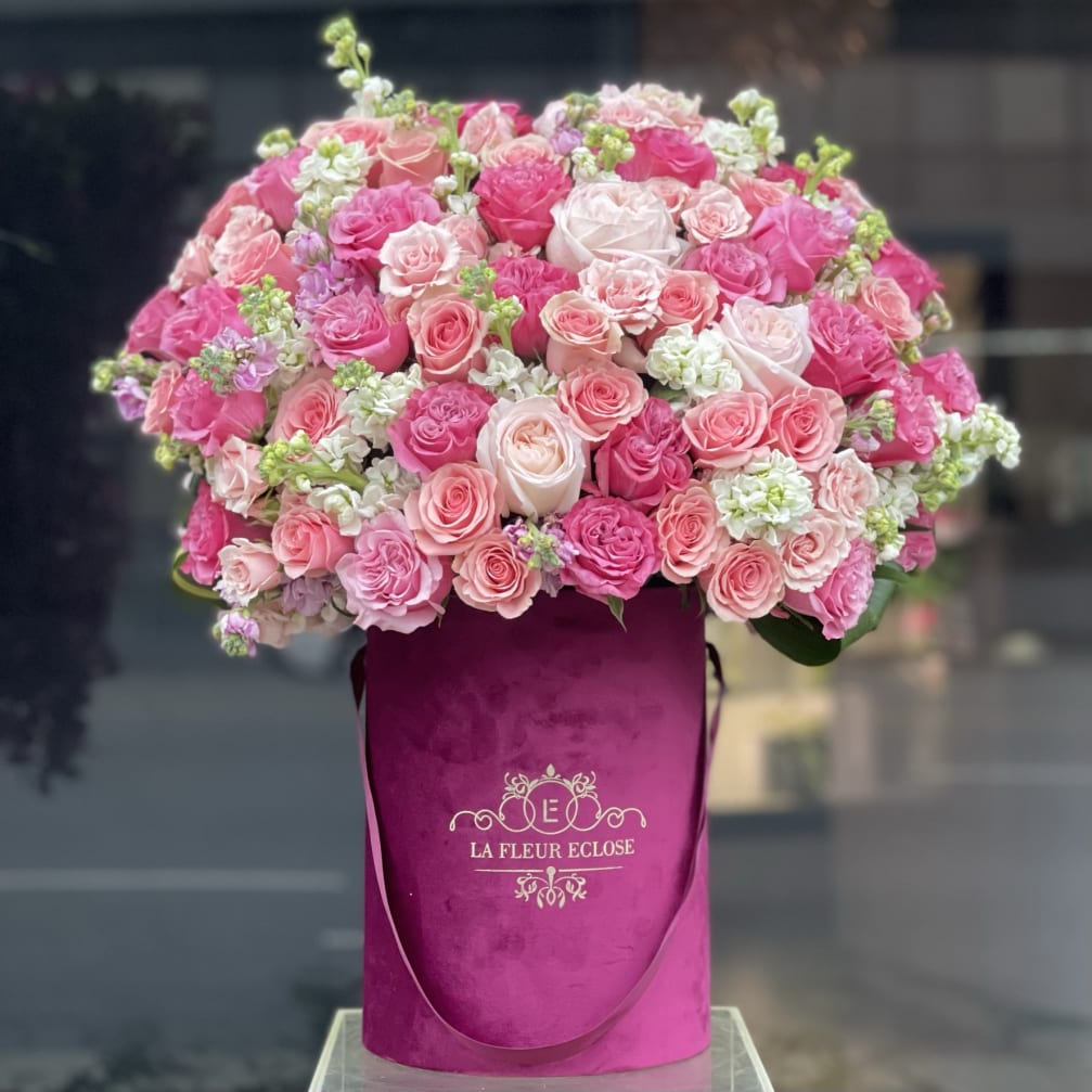 Large pink rose arrangement in a magenta hatbox
