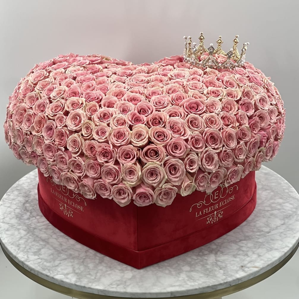 Heart-shaped pink rose arrangement with a small crown on top
