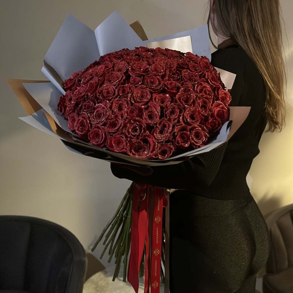 Large bouquet of deep red roses wrapped in paper