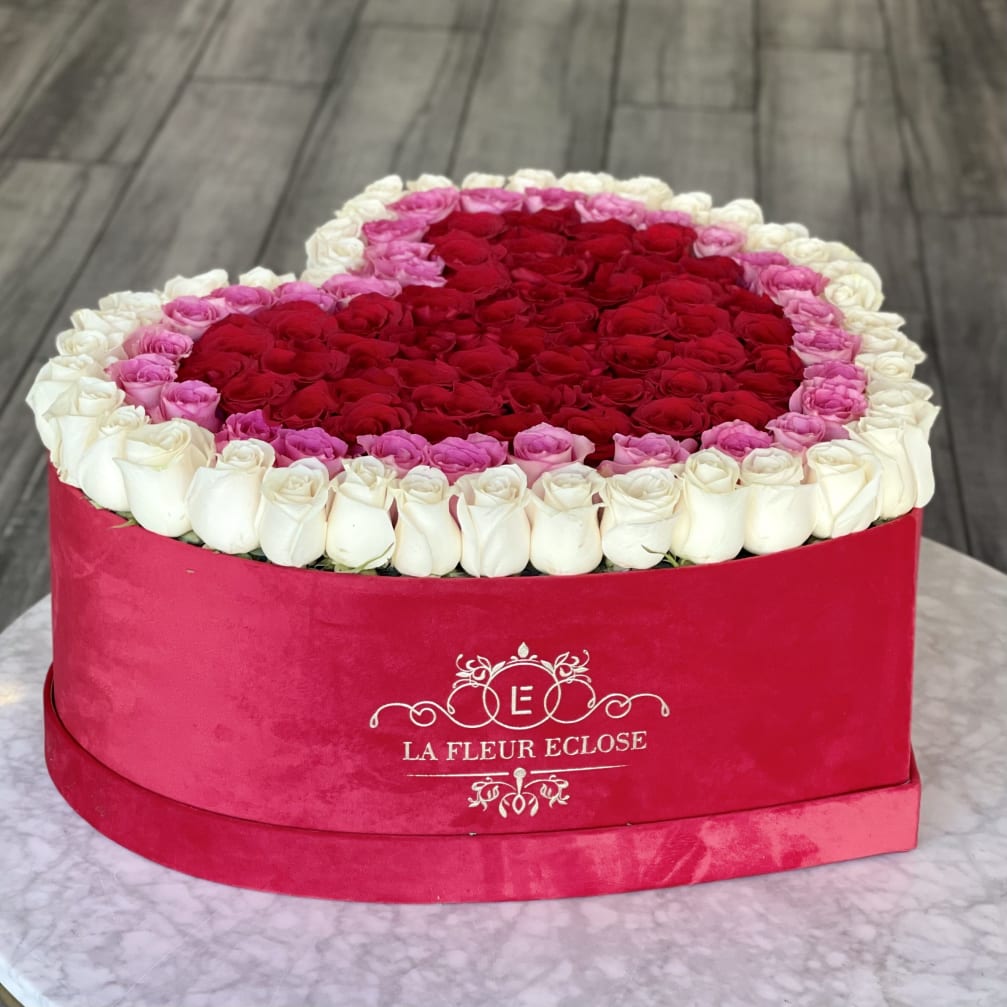 Heart-shaped box filled with red, pink, and white roses